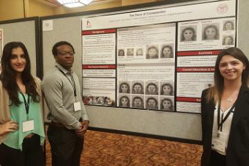Three people presenting a research poster titled Koopmann-Holm Lab.