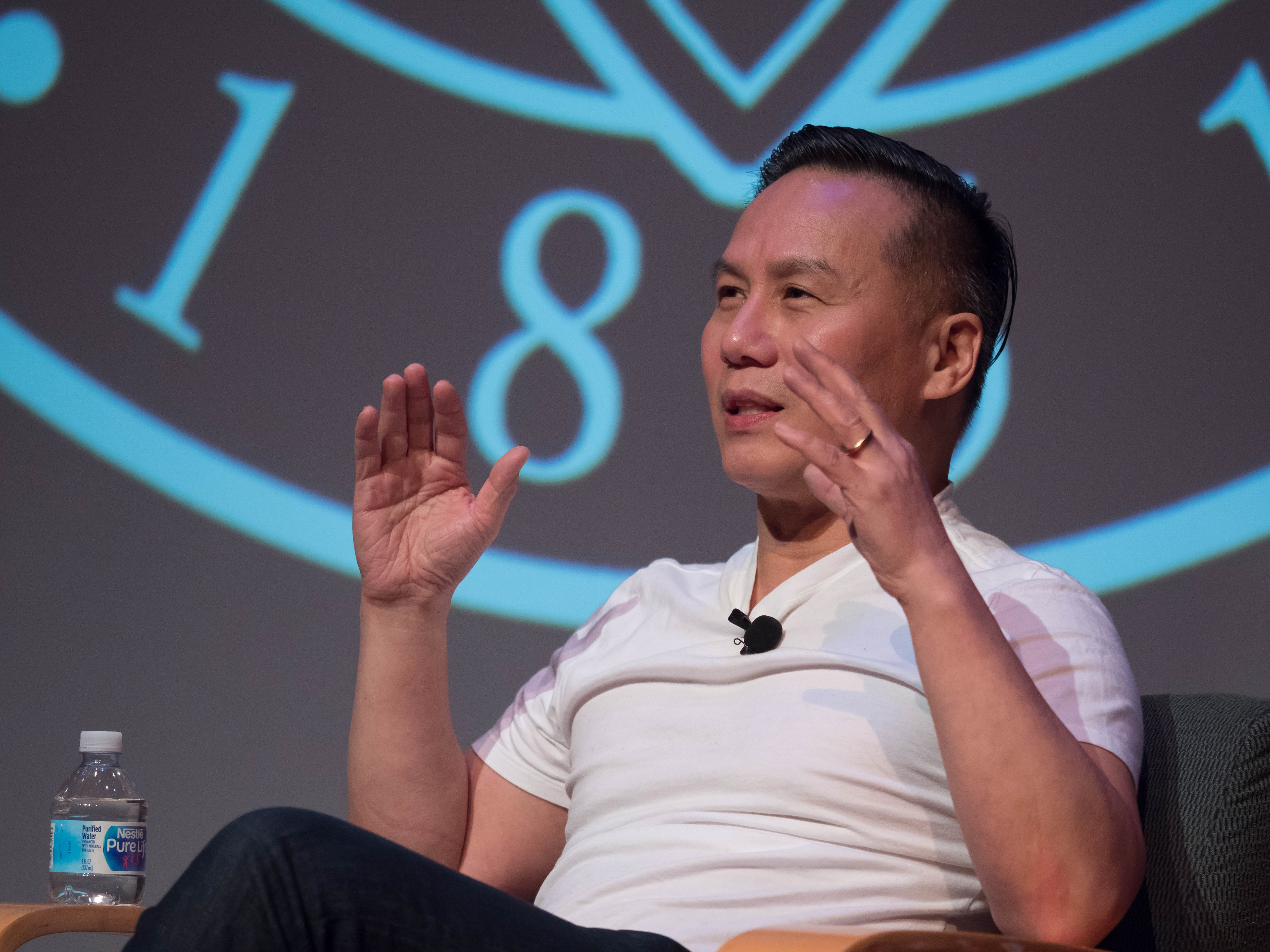 A person speaking at an AAPI event with 187 in the background.