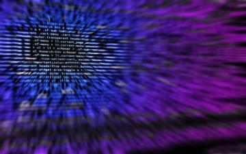 Cybersecurity text over a background of computer code.