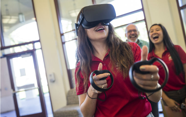 Student using VR glasses with observers behind image link to story