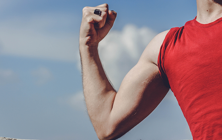 Arm flexing muscle in red cut off shirt