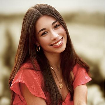 Woman outdoors in red top smiling