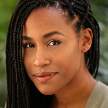 Portrait of Malarie Howard with greenery in the background.