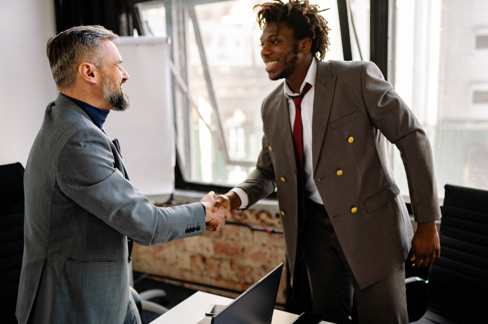 Sports business professionals shaking hands over an NIL deal