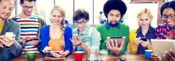 Group of people looking at electronic devices; titled 'Hero Feature Banner'.