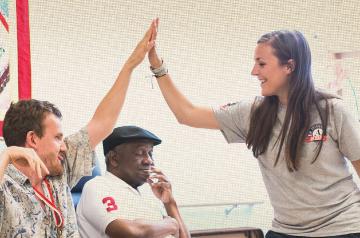 Three people high-fiving in a casual, cheerful setting.