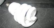 Compact fluorescent lightbulb on a dark surface.