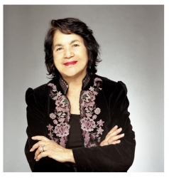 Person wearing a black jacket with white and purple floral embroidery, smiling. image link to story
