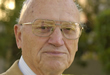 An elderly person wearing glasses and looking at the camera. image link to story