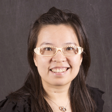 A person wearing glasses, smiling at the camera.